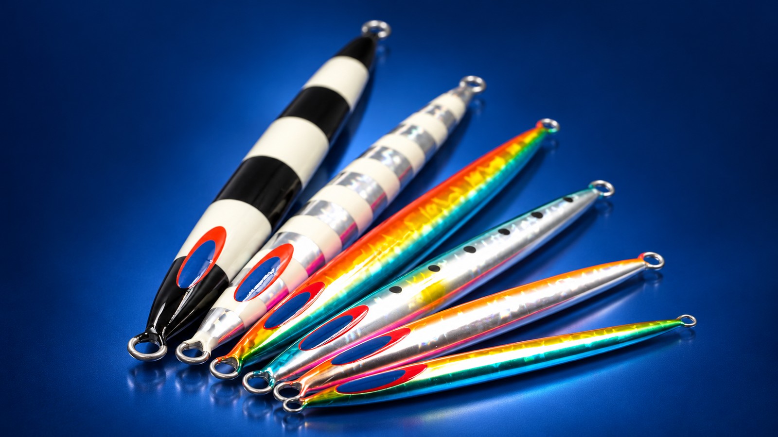 Seis jigs Deep Liner SPY-N con distintos acabados, dispuestos en abanico sobre un fondo de estudio azul.